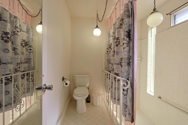 bathroom featuring a shower with curtain, tile patterned floors, and toilet