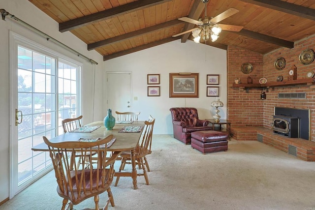 dining room featuring a wood stove, vaulted ceiling with beams, light colored carpet, and wood ceiling