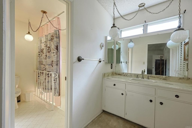 bathroom with vanity, a textured ceiling, and toilet