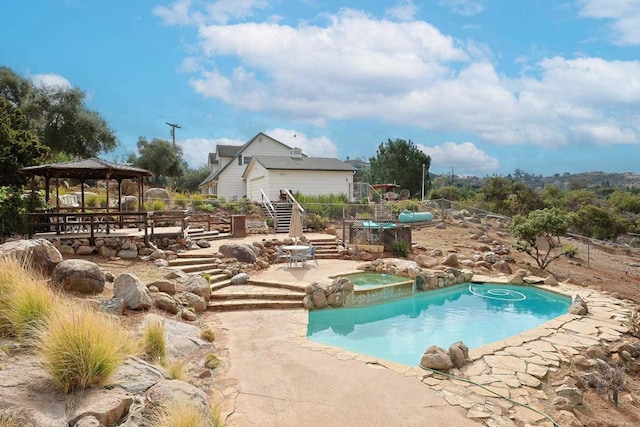 view of swimming pool with a gazebo and an in ground hot tub