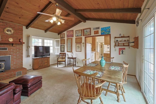 carpeted dining area featuring wood ceiling, lofted ceiling with beams, ceiling fan, and a wood stove