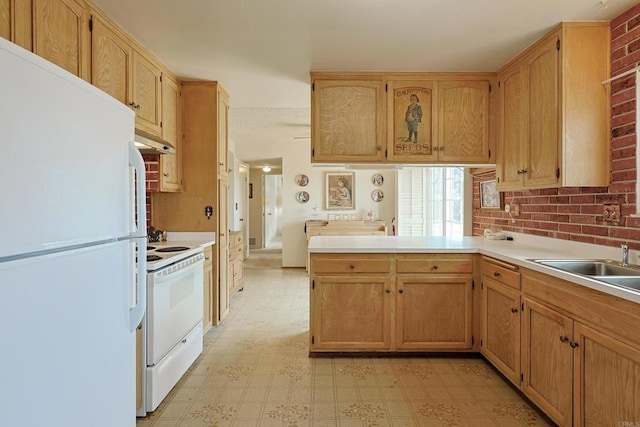 kitchen featuring sink, white appliances, kitchen peninsula, and brick wall