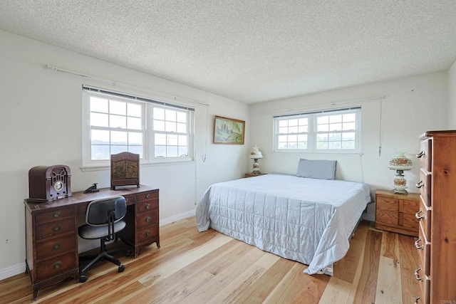 bedroom featuring a textured ceiling and light wood-type flooring