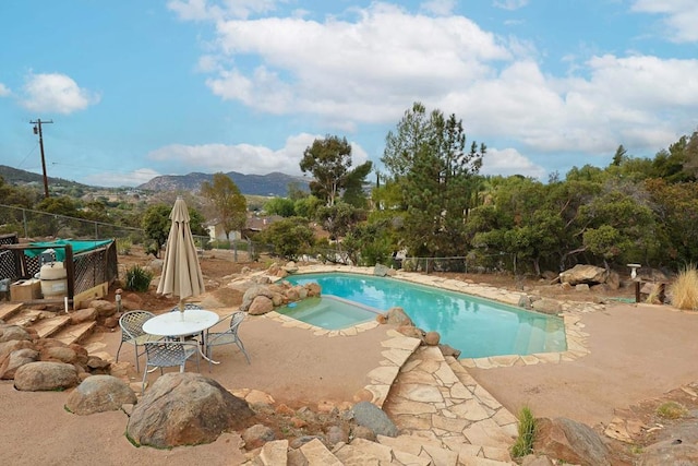 view of pool with an in ground hot tub, a mountain view, and a patio