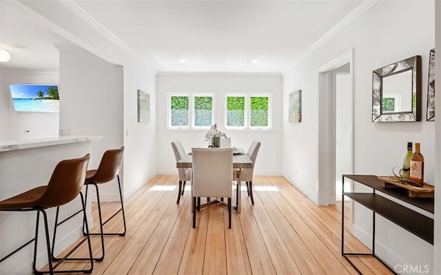 dining room featuring crown molding and light hardwood / wood-style floors