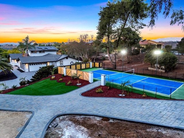 view of community featuring tennis court and a lawn