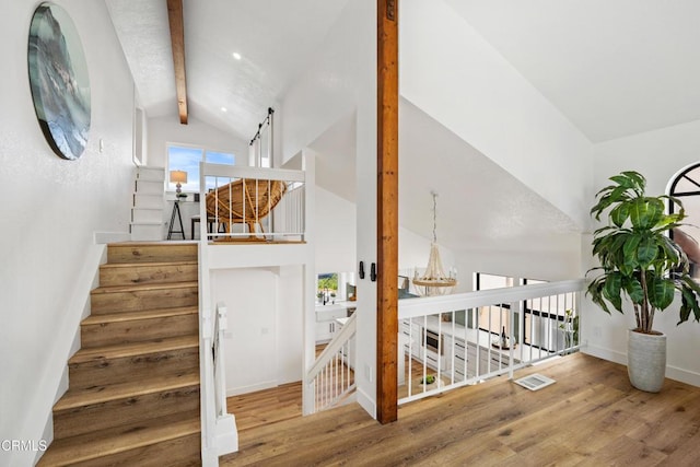 stairs featuring lofted ceiling with beams, baseboards, a chandelier, and wood finished floors