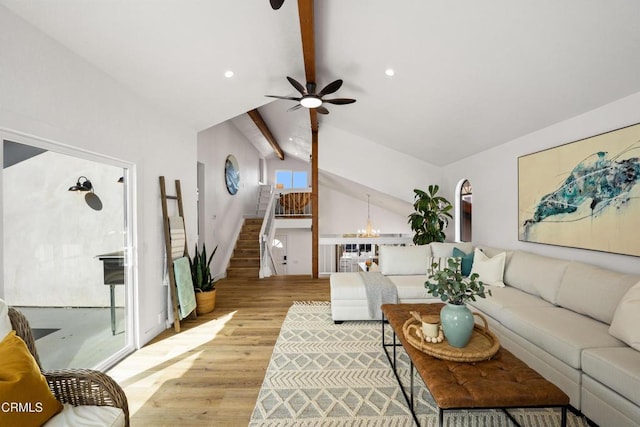 living area featuring light wood finished floors, recessed lighting, stairway, lofted ceiling with beams, and ceiling fan with notable chandelier