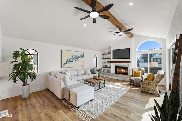 living room with a tiled fireplace, wood finished floors, high vaulted ceiling, beamed ceiling, and baseboards