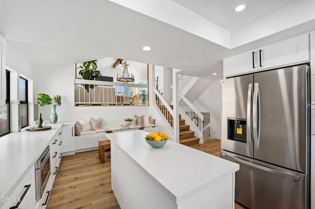 kitchen with recessed lighting, white cabinets, light countertops, appliances with stainless steel finishes, and light wood finished floors