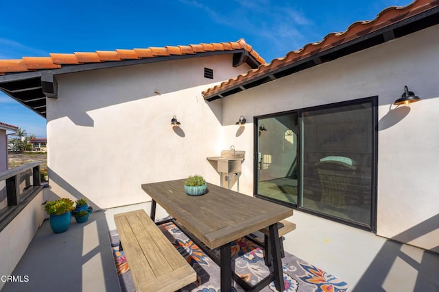 view of patio with outdoor dining area and a sink