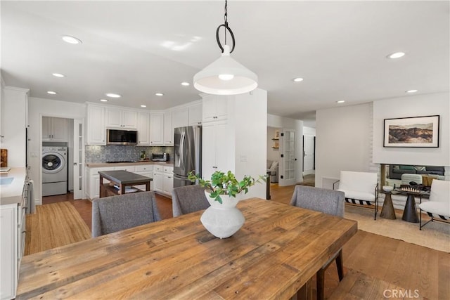 dining room with hardwood / wood-style flooring and washer / dryer