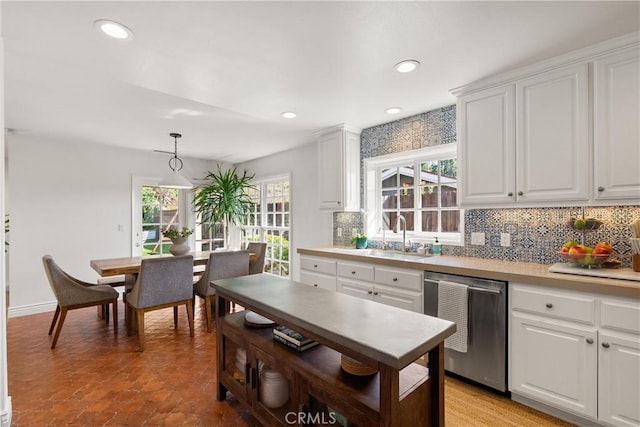 kitchen with sink, dishwasher, white cabinets, decorative backsplash, and pendant lighting