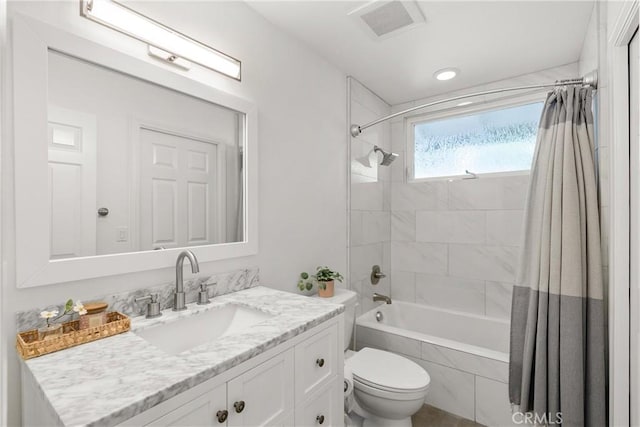 full bathroom with shower / tub combo with curtain, vanity, and toilet