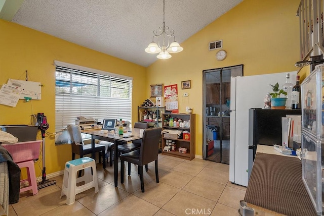 dining area with lofted ceiling, a textured ceiling, a chandelier, and light tile patterned flooring