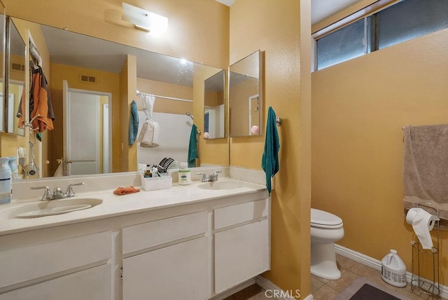 bathroom featuring tile patterned flooring, vanity, walk in shower, and toilet