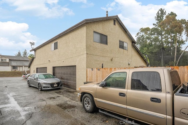 view of side of home featuring a garage and washer / dryer