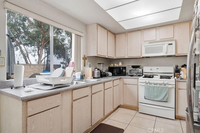 kitchen featuring light tile patterned floors, white appliances, and light brown cabinets