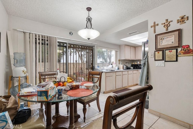 tiled dining space featuring a textured ceiling