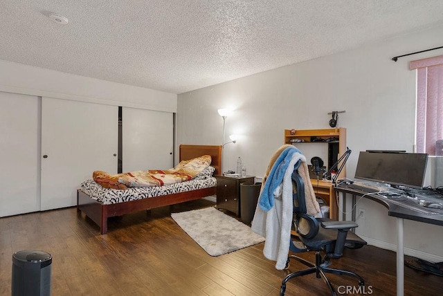 bedroom featuring a textured ceiling, dark hardwood / wood-style flooring, and a closet