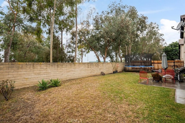 view of yard featuring a fire pit, a trampoline, and a patio area