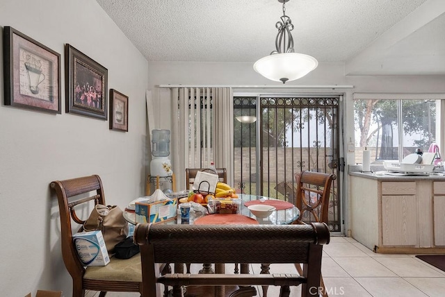 tiled dining room with a textured ceiling