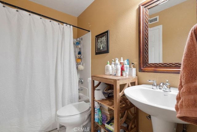 full bathroom featuring sink, shower / tub combo with curtain, and toilet