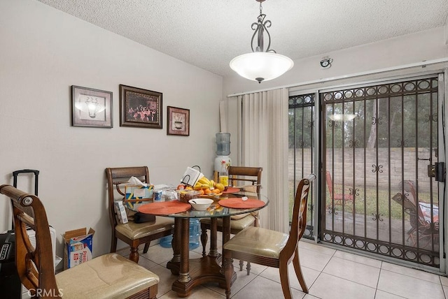 dining room featuring plenty of natural light, light tile patterned floors, and a textured ceiling