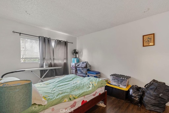 bedroom featuring dark hardwood / wood-style floors and a textured ceiling