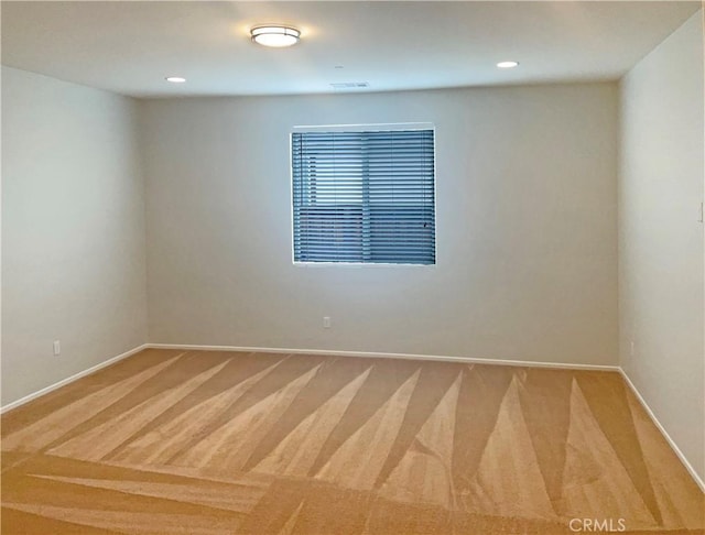 empty room featuring baseboards, recessed lighting, and light colored carpet