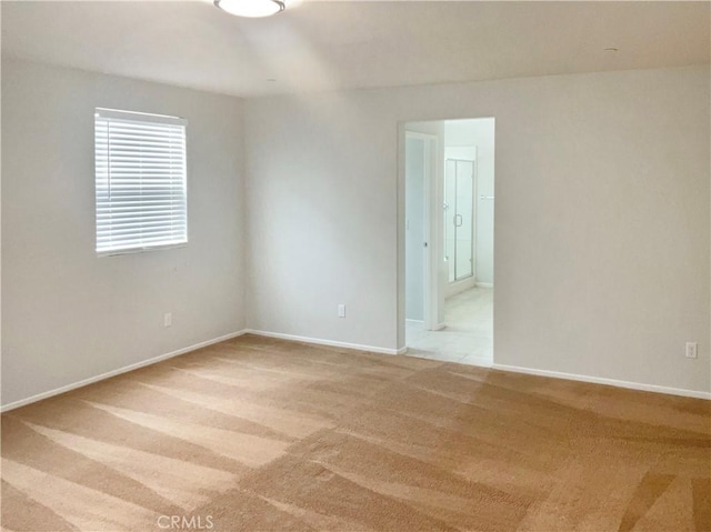 empty room with baseboards and light carpet