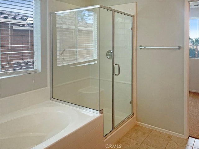 bathroom with tile patterned flooring, baseboards, a bath, and a shower stall