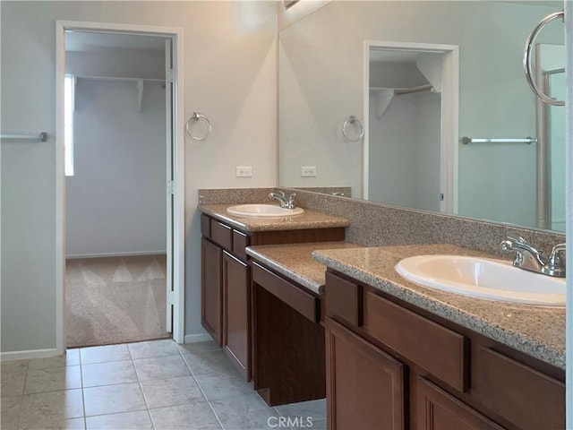 full bathroom with baseboards, a walk in closet, tile patterned flooring, and vanity