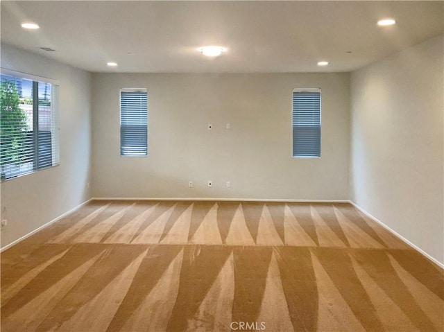 carpeted empty room with baseboards and recessed lighting