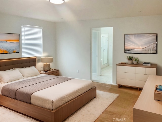 bedroom with light carpet and ensuite bath