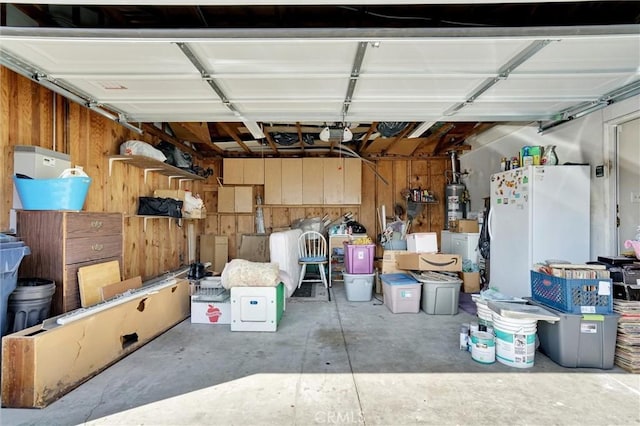 garage with water heater and white fridge