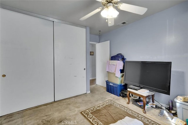 carpeted bedroom featuring ceiling fan and a closet