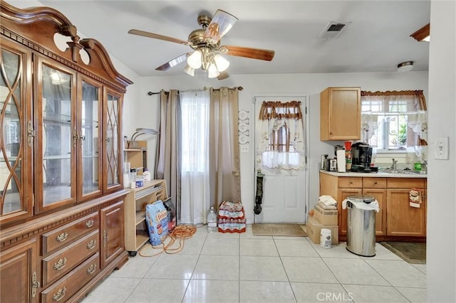 kitchen featuring ceiling fan, sink, and light tile patterned floors