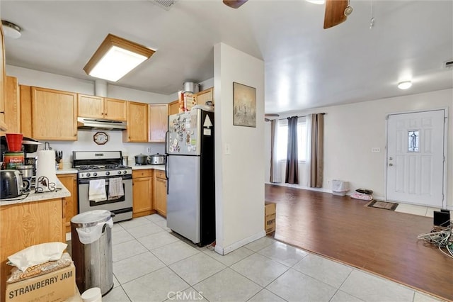 kitchen with light brown cabinetry, light tile patterned floors, and appliances with stainless steel finishes