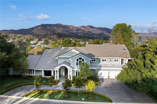 view of front of house with a mountain view, a chimney, driveway, and a tile roof