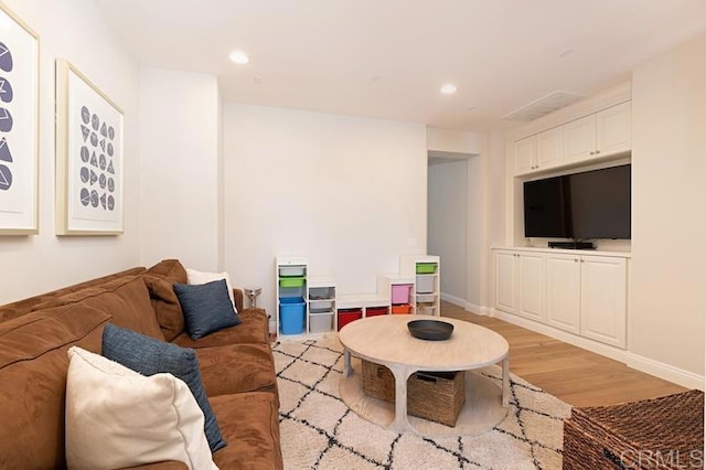 living room with light wood-style flooring, baseboards, and recessed lighting