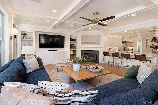 living room with coffered ceiling, a fireplace, beamed ceiling, and light wood finished floors