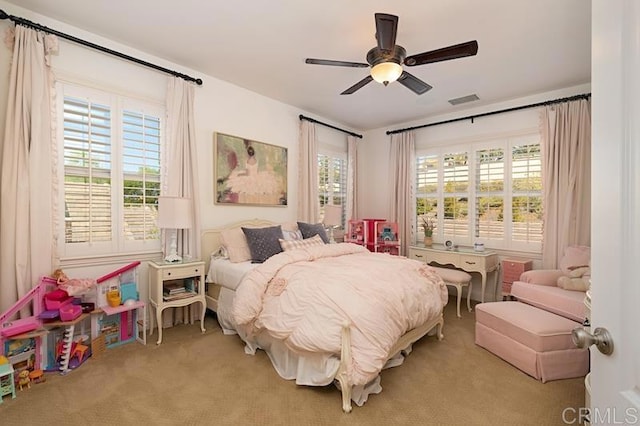 bedroom featuring light carpet, visible vents, and a ceiling fan