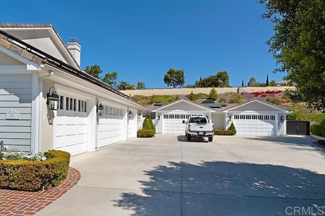 exterior space with concrete driveway and a chimney