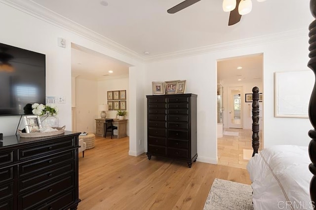 bedroom with light wood-style flooring, ornamental molding, and ensuite bathroom