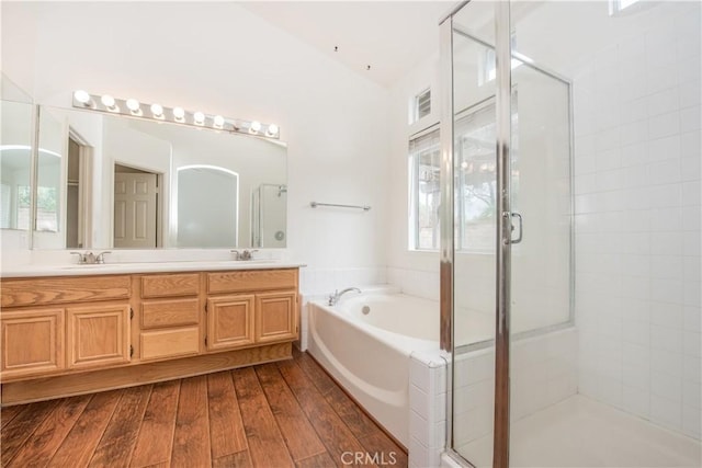 bathroom with vanity, hardwood / wood-style floors, a healthy amount of sunlight, and separate shower and tub