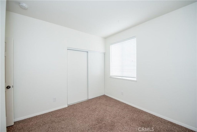 unfurnished bedroom featuring a closet and carpet