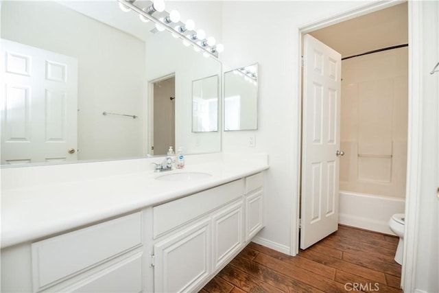 full bathroom with bathtub / shower combination, vanity, toilet, and hardwood / wood-style floors