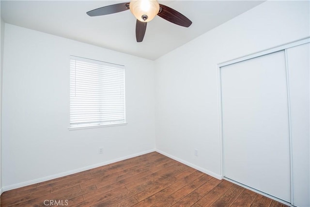 unfurnished bedroom featuring ceiling fan, dark hardwood / wood-style flooring, and a closet