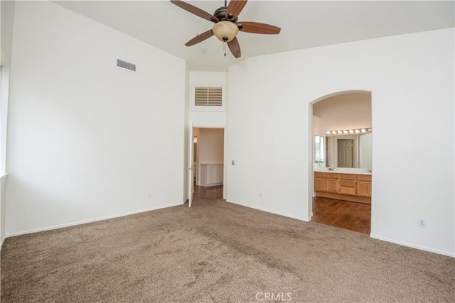 unfurnished bedroom featuring carpet, connected bathroom, and ceiling fan